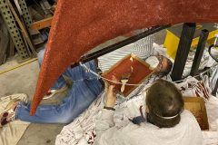 F. Hudson Miller has to get onto his back to apply cranberry seeds to the bottom of the glider ---- Photo by Erik C. Andersen